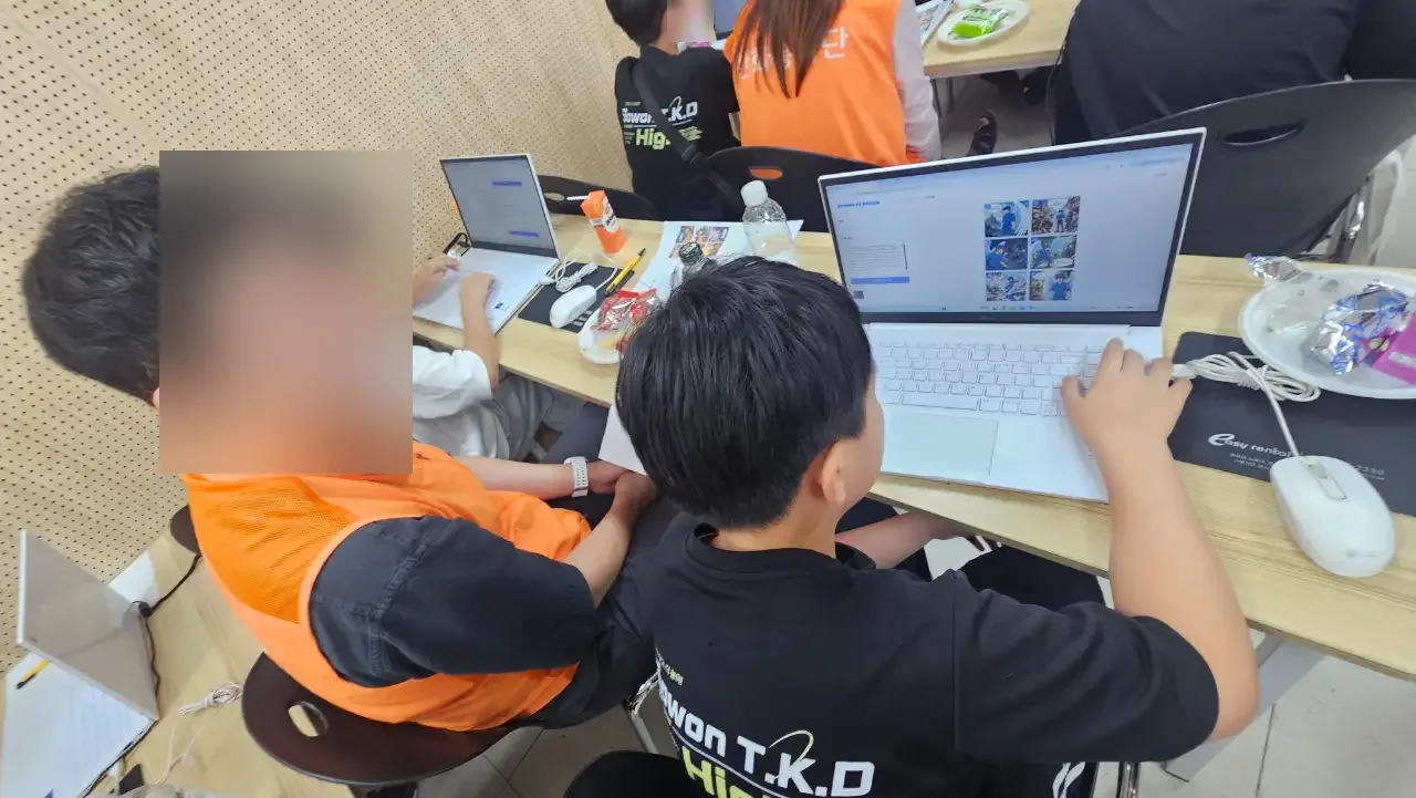 노트북 앞에서 아동을 지도하는 임직원 멘토 (얼굴 흐림 처리)