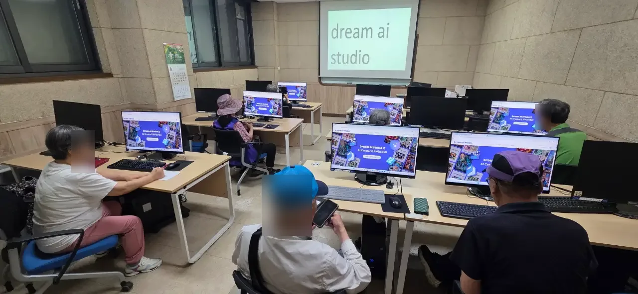 컴퓨터실 스크린과 모니터 앞의 시니어 수강생들 (얼굴 흐림 처리)